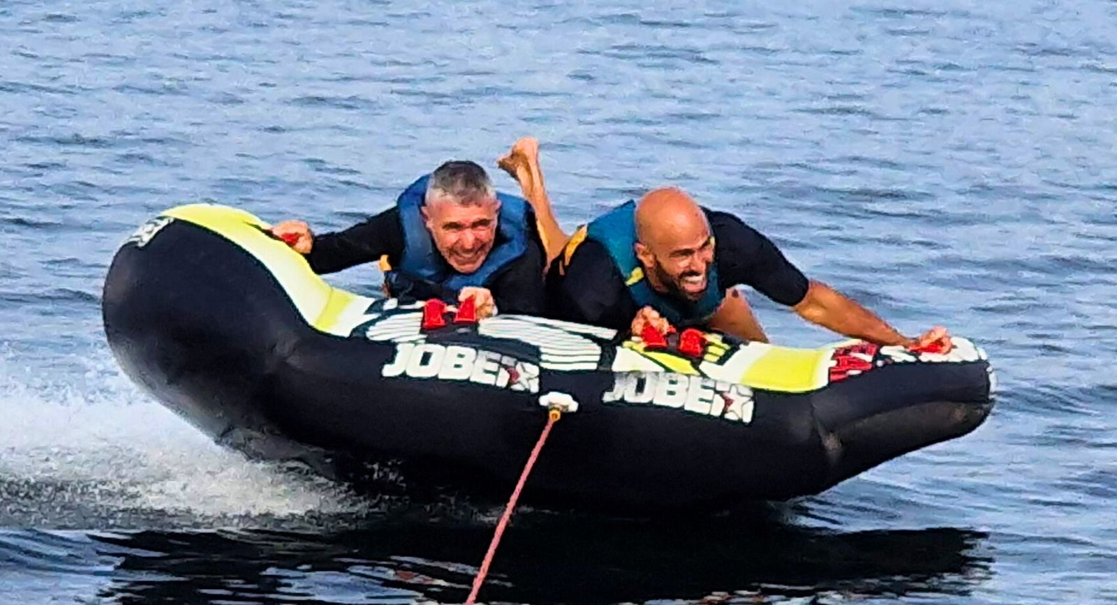 Deux amis sur la bouée tractée, éclats de rire